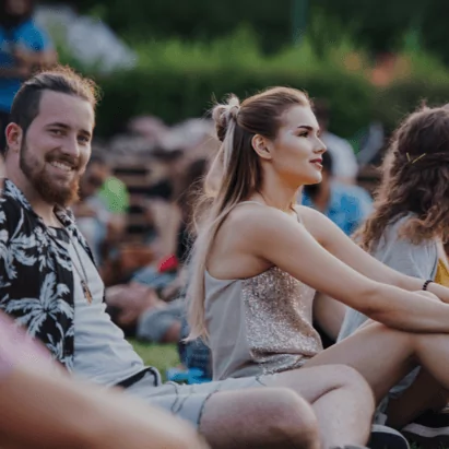 A group of people watching the live concert from the open fields